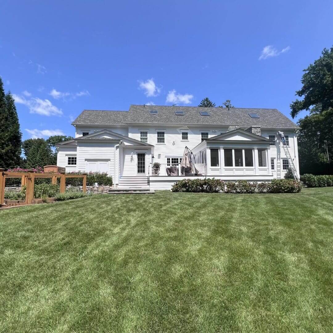 Large white building with a sloped roof and well-maintained green lawn.