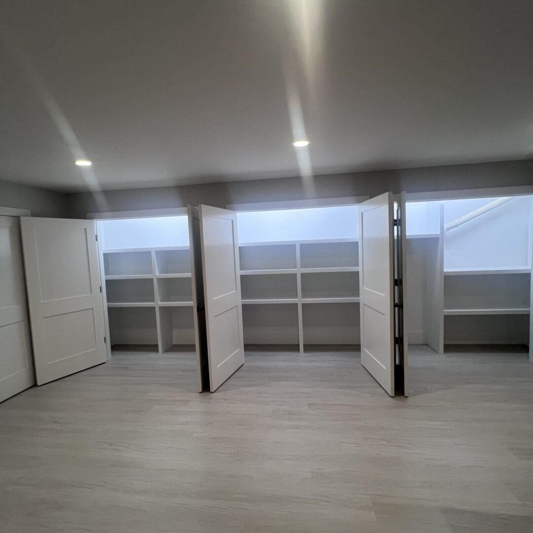 Empty room with large windows and sliding doors.