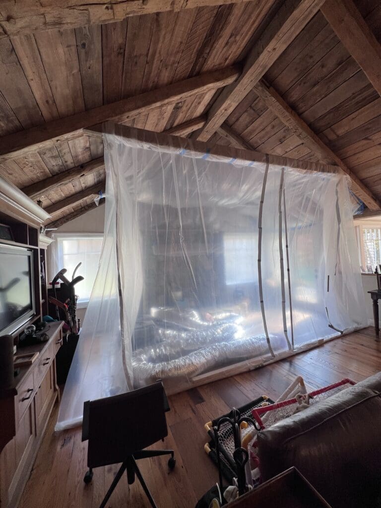 A large transparent plastic sheet hanging inside a rustic wooden room.