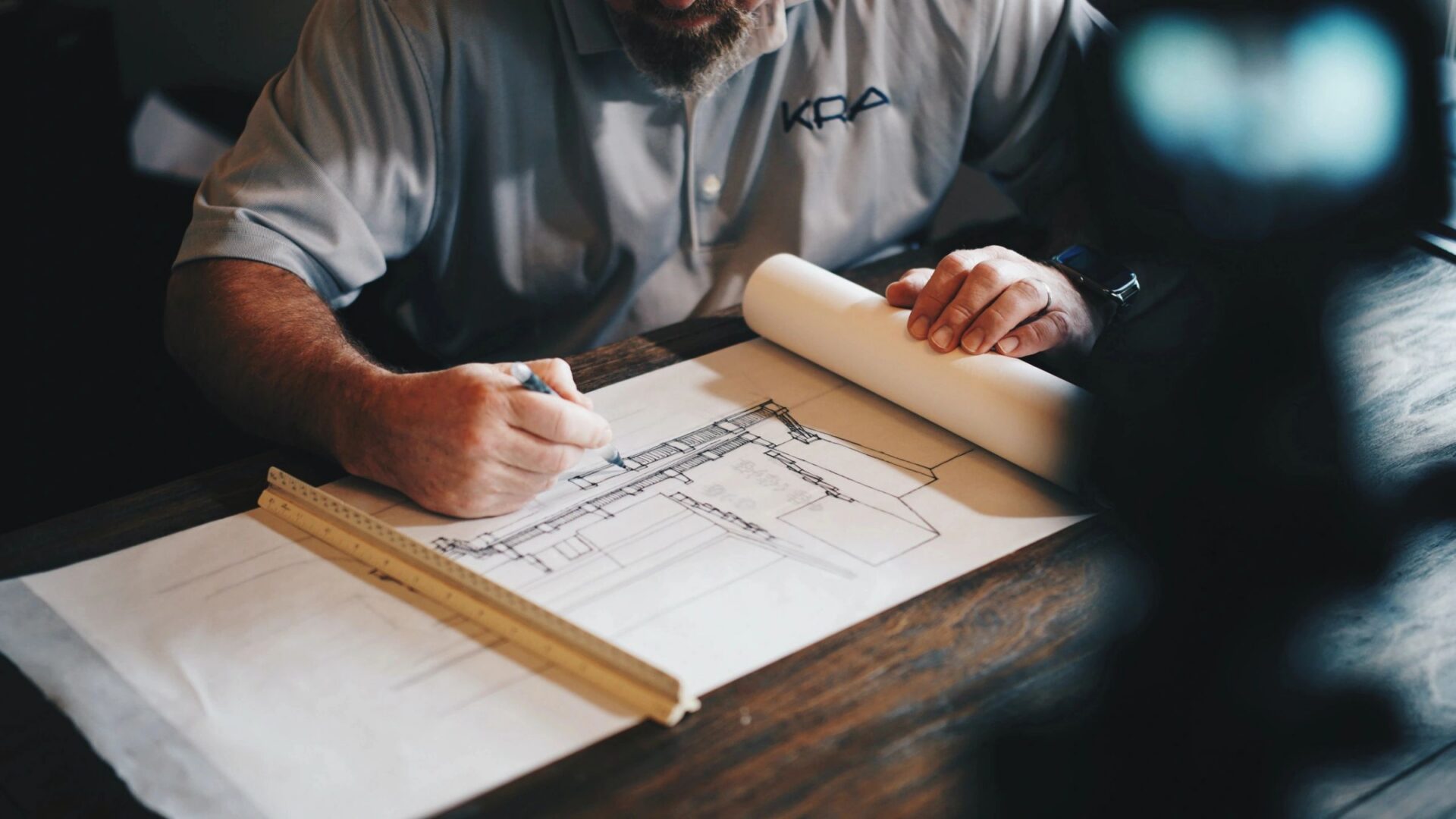 Person sketching architectural plans on paper.